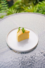Delicious slice of Japanese cheesecake topped with fresh mint on a plate offers a light, airy taste