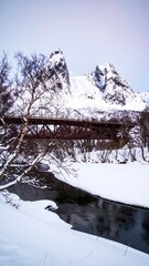 Snowy mountain valley with a bridge