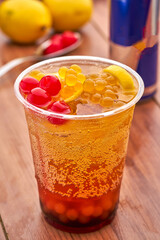 Cherry Mojito Citrus Boba Drink with Popping Pearls and Lemon Garnish in plastic cup closeup side view of summer drink