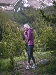 Blonde Athletic Woman Admiring Mountain Views on Autumn Evening Hike in Forest Path