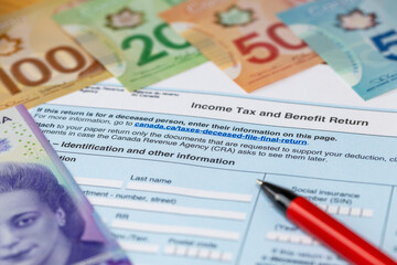 Income tax and benefits in Canada. Financial business concept. Ready tax return, Canadian dollars, pen.