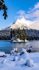 Snowy mountain vista by a frozen lake
