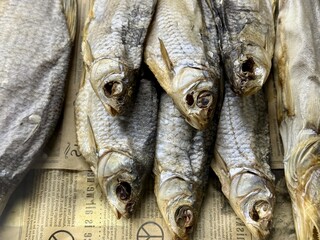 Obraz premium A delightful dried fish exhibit, beautifully decorated on an unknown newspaper background, demonstrates traditional ways of selling and preserving products. Appetizer for beer