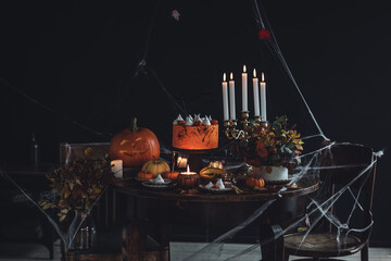 Homemade delicious chocolate cake with coloured orange cream and meringue ghosts, pumpkins for...