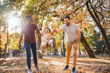 Joyful swing between parents in the park