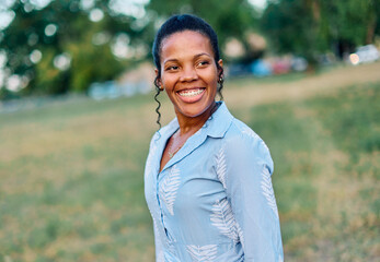 Happy young black woman meditating and daydreaming and relaxing and having fun in nature outdoors