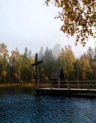 Wooden chapel on a serene lake, autumn colors