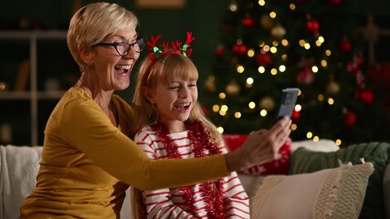 Grandmother and granddaughter making christmas video call - Powered by Adobe