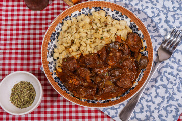 Delicious hungarian goulash with spaetzle served on decorative plate