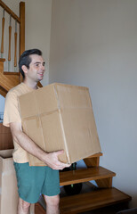 Man carrying a cardboard box indoors
