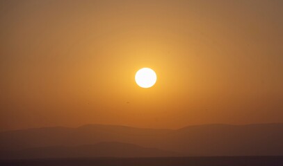 Sunset at the Trijueque viewpoint with intense haze in the sky and a scorching sun of intense orange