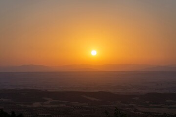Sunset at the Trijueque viewpoint with intense haze in the sky and a scorching sun of intense orange