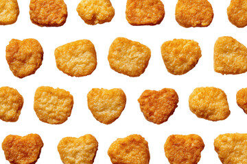 Crispy, golden-brown food pieces, arranged in a grid pattern on a black background.  Each piece has a slightly irregular, heart-shaped form and a crunchy, textured surface.  Close-up view