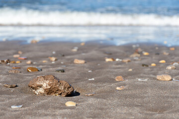 Selective focus on a stone in the sand at the seashore.