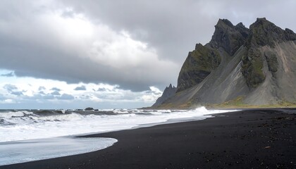 Dramatic black sand beach meets rugged mountains under a stormy sky