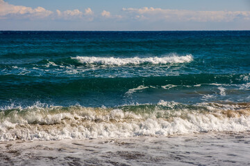 Sea wave breaks on sandy beach with clouds sky on Mediterranean coast of Mersin province, Atakent