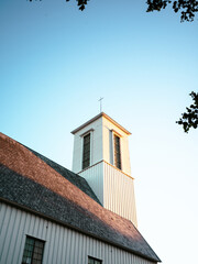 Bell tower of a church in Melbu in the sun and stone roof tiles