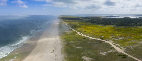 Clouds drift above the scenic Nauset Beach in Orleans, Cape Cod, Massachusetts. This aesthetic public beach is a popular destination for people on vacation during summer months. 