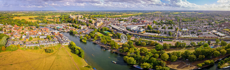 Aerial view of Windsor Castle surrounded by town buildings and lush green landscape