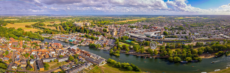 Aerial view of Windsor Castle surrounded by town buildings and lush green landscape