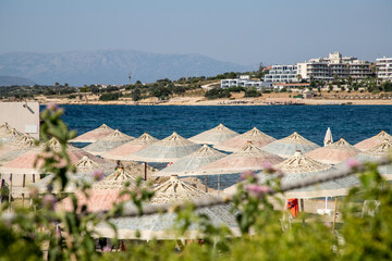 Sunny Beach Scene with Resort and Mountain in the Background