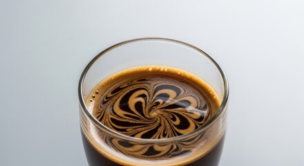 Swirling Coffee Art: Close-Up of Dark Brew in Glass with Abstract Pattern