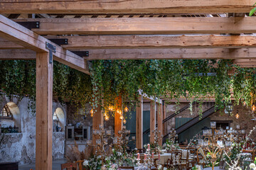 Elegant wedding celebration featuring beautifully decorated tables with crystal glasses, lush greenery, and warm lighting creating a stylish atmosphere for a memorable party experience