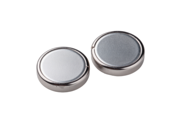 Two round, metallic, button-style batteries sit side-by-side, slightly angled, against a plain black background.  They are a silvery-gray color