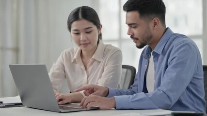 Two people collaborating on a laptop.