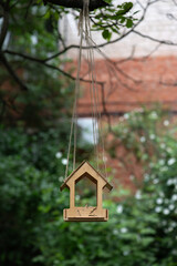 Wooden bird feeder in the courtyard of an apartment building. Shallow depth of field.