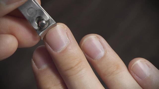 Man cuts fingernails using nail clipper, close-up shot video. Man cutting his long middle fingernail