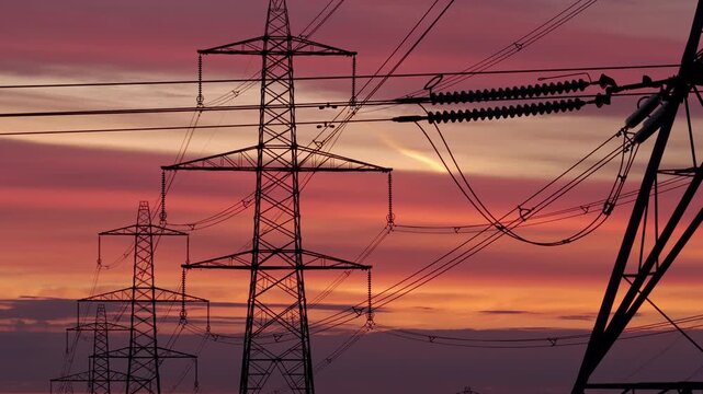 Vibrant Sunrise Over Yorkshire Pennines with Silhouette Electricity Pylons and Power Grid Infrastructure