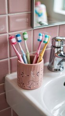 Colorful Toothbrushes in Cup on Bathroom Sink  
