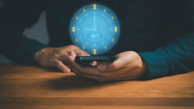 24/7 online payment and mobile banking concept with hands holding smartphone and digital clock surrounded by dollar symbol. Real-time finance, fintech services, money transfer and global transactions.
