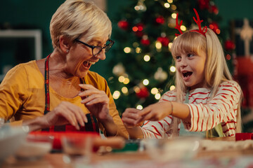 Grandmother and granddaughter wrapping christmas presents together