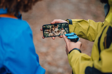 Hikers using mobile phone gps app for navigation in mountain trail