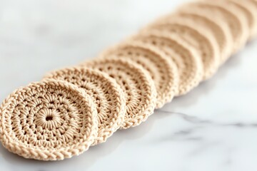 Close-up of handmade crocheted coasters on a marble surface, showcasing intricate detail and craftsmanship.