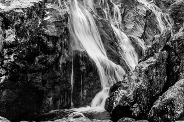 A waterfall is flowing down a rocky cliff