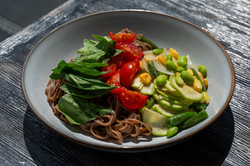Top view of a dish of buckwheat noodles with vegetables. 