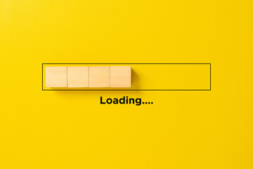 Loading bar concept made of wooden blocks inside a progress bar on yellow background, symbolizing process, waiting time, development, and technology progress.