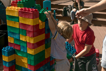 Obraz premium Child playing with big LEGO bricks outside, creative activity and fun learning