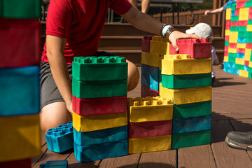 Obraz premium 10-year-old boy building large LEGO outdoors