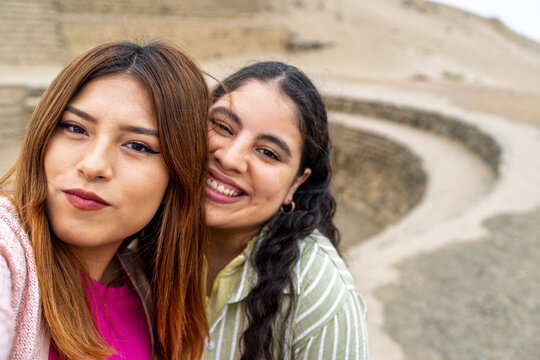 Tourists taking selfie at cantalloc aqueducts in nazca desert, peru