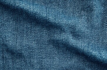 Close-up view of blue denim fabric showing detailed weave texture and subtle folds with natural shading