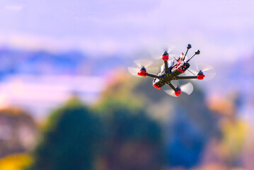 Fpv drone flying at high speed on a sunny day. The quadcopter is in the air viewed from the ground. 