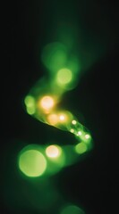 A blurred image of a flowing, green and gold light trail on a dark background creates a surreal, ethereal, and dreamy visual effect