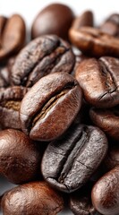 Close-up of roasted coffee beans in varying shades of brown. The beans display rich textures and distinct grooves, creating a warm and aromatic visual