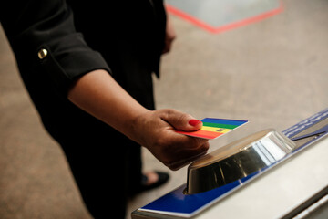 Businesswoman using rainbow metro card entering subway station