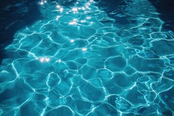 Fototapeta premium Sunlight sparkling on clear blue water surface with gentle ripples creating dynamic reflections