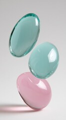 Three translucent stones, two aqua and one pink, are stacked with a slight space between them against a bright, neutral background